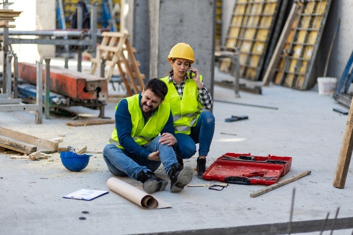 Two construction workers are sitting on the ground after a construction accident in Owings Mills, MD