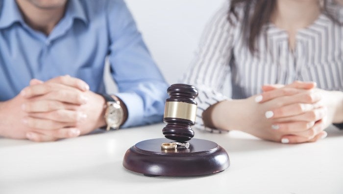 A judge’s gavel rests on the table as two people discuss a family law divorce case in Owings Mills