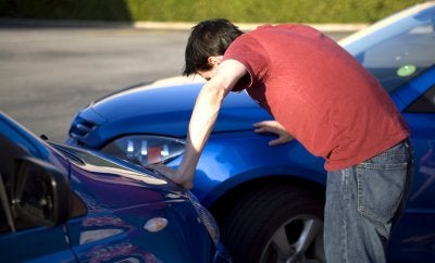 Man inspecting his car after an accident in Owings Mills, MD
